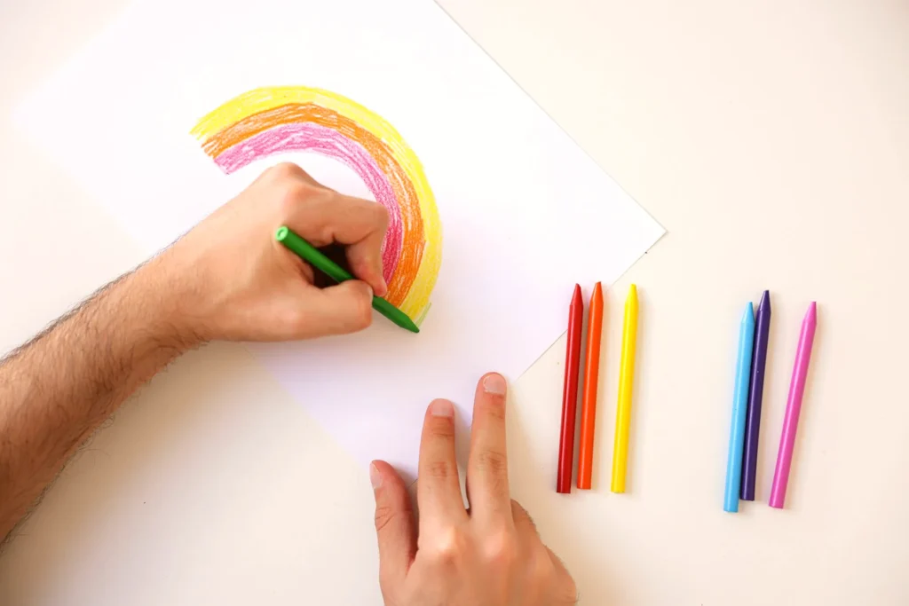 Dibujo de un arcoíris con crayones sobre la mesa