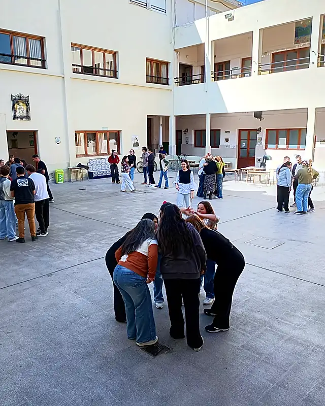 Docentes realizan una dinámica grupal en el patio de una escuela